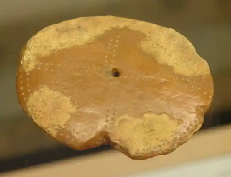 Dotted cross on a clay solar disc